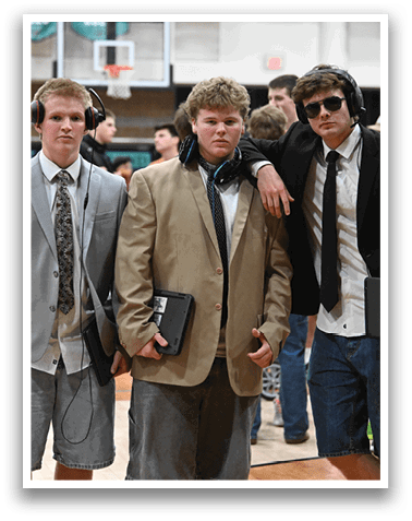Three young men wearing suits and ties stand together on a basketball court. AI generated content