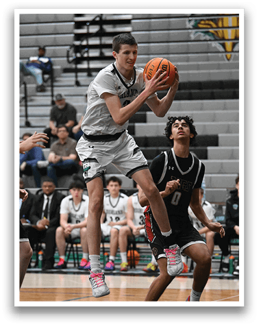 A basketball player jumps in the air to catch the ball while another player tries to block him. AI generated content