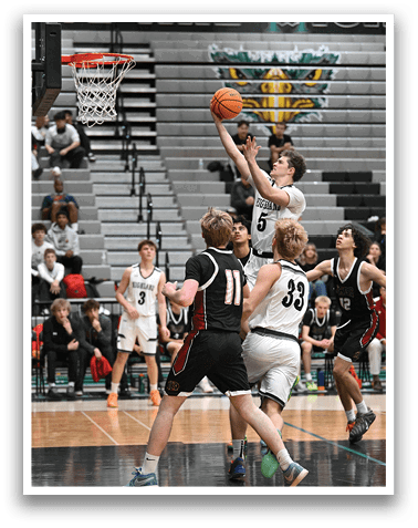 A basketball player is jumping to block a shot, while other players on the court look on. AI generated content