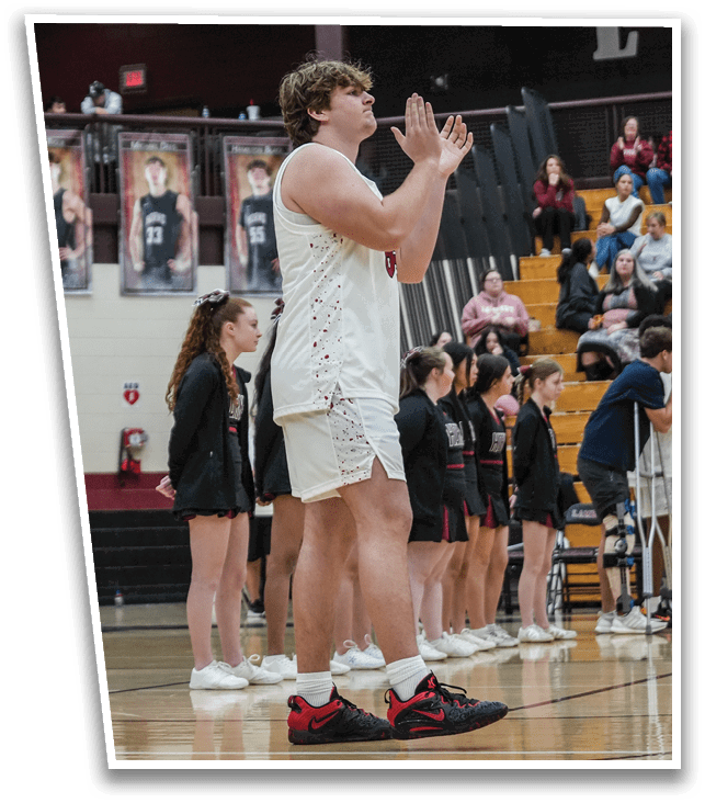 A man in a white jersey stands on a basketball court, clapping his hands. AI generated content