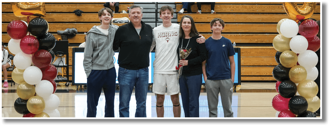 A group of people, including a man and a woman, pose for a picture on a basketball court. AI generated content