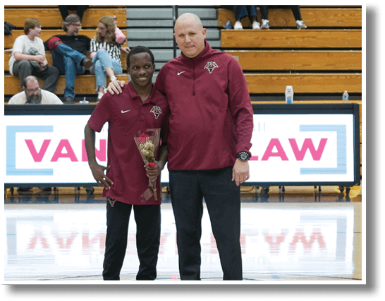Two men are standing on a basketball court, one of them holding a trophy. They are posing for a photo. AI generated content