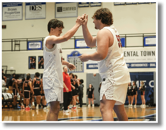Two men are high-fiving each other on a basketball court. AI generated content