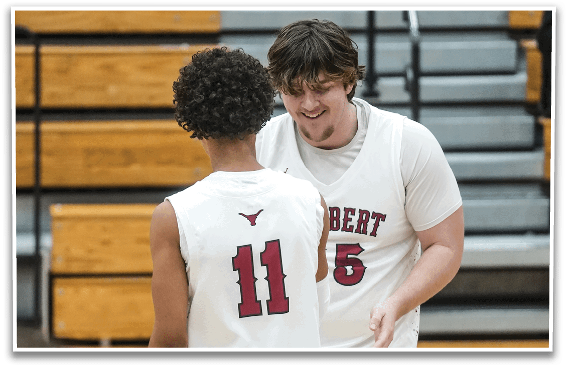 Two men wearing white jerseys are hugging each other on a basketball court. AI generated content