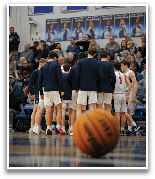 A group of men wearing blue jackets are standing around a basketball court. AI generated content