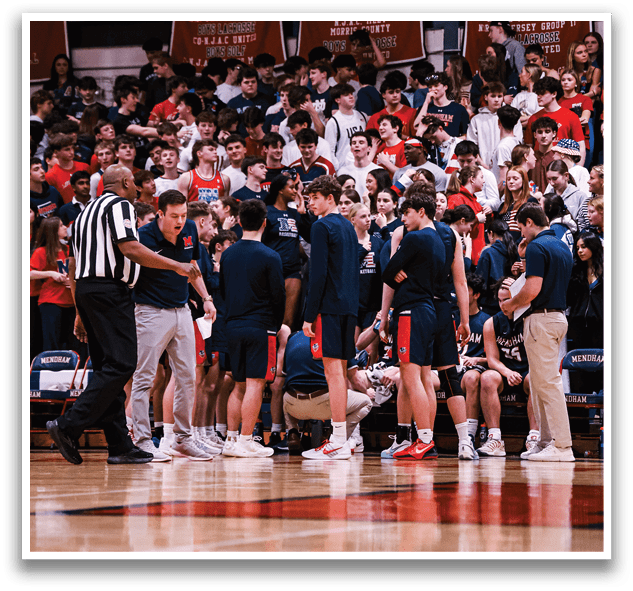 A group of people are gathered on a basketball court, with some sitting on a bench and others standing. A referee is present, overseeing the game. AI generated content