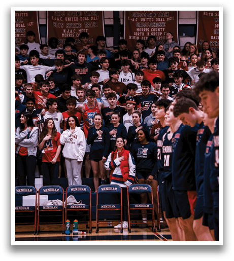 A group of people are standing on a basketball court, some of them wearing red and white uniforms. They are lined up, possibly for a game or a performance. The crowd is watching them, and there are several chairs placed around the court. AI generated content