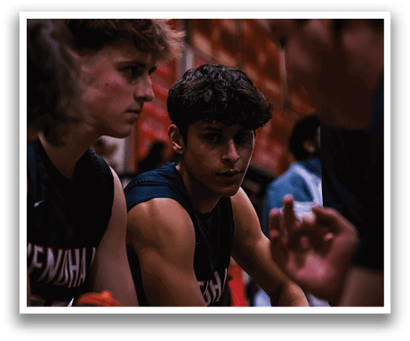 Three young men are sitting in a row, wearing black shirts and shorts. They are looking at something in front of them, possibly a game or a presentation. AI generated content