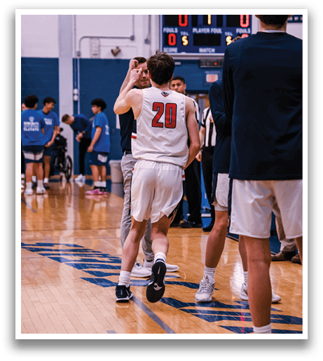 A group of people are on a basketball court, with one man wearing a white jersey and the number 20. The man is holding a basketball in his hand. AI generated content