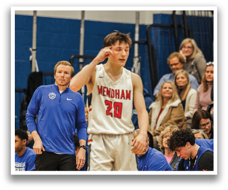 A basketball player wearing a number 20 jersey stands on the court, holding a phone to his ear. AI generated content