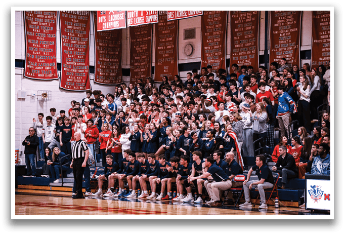 A crowd of people is watching a basketball game, with a referee and a group of players on the court. The spectators are seated on chairs and benches, and some are standing. The atmosphere is lively, with people cheering and enjoying the game. AI generated content