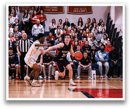 A basketball game is in progress with a crowd of spectators watching. Two players are on the court, one holding a basketball and the other trying to block him. The players are wearing uniforms and the crowd is engaged in the game. AI generated content