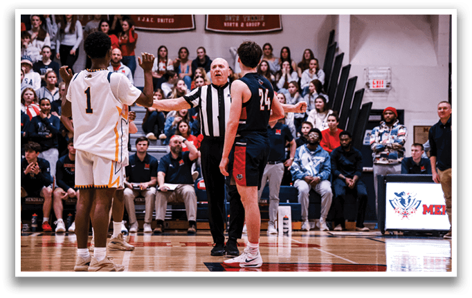 A basketball game is taking place with a referee and two players on the court. The referee is holding his hand up, and the players are engaged in the game. The crowd is watching the game intently, and there are several chairs placed around the court. AI generated content