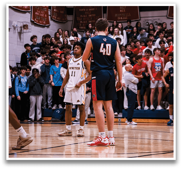 A group of people are standing on a basketball court, with some of them wearing uniforms. The crowd is watching the game, and there are several people standing in the background. The players are standing on the court, and some of them are wearing red and blue uniforms. AI generated content