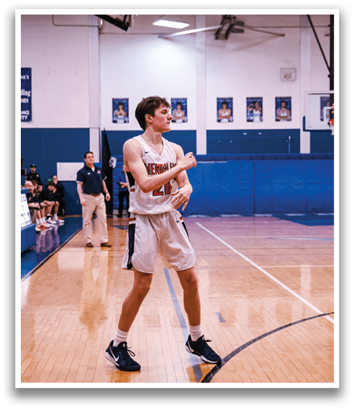 Two basketball players are on the court, one wearing a white jersey and the other wearing a blue jersey. They are both holding basketballs and appear to be playing a game. There are several other people in the background, some of whom are also holding basketballs. AI generated content