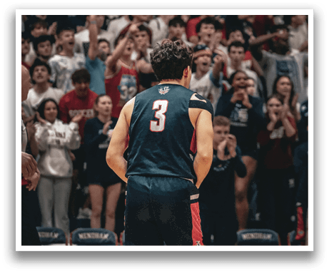 A man wearing a basketball uniform walks onto the court while fans cheer him on. AI generated content