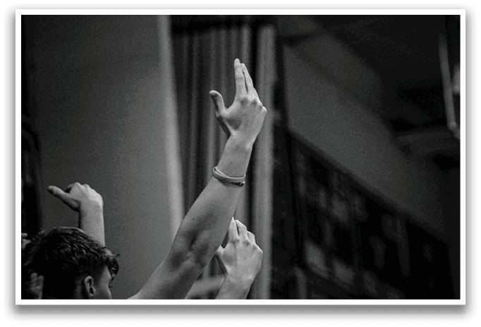 A group of people are in a stadium, watching a game. They are holding up their hands and cheering. AI generated content