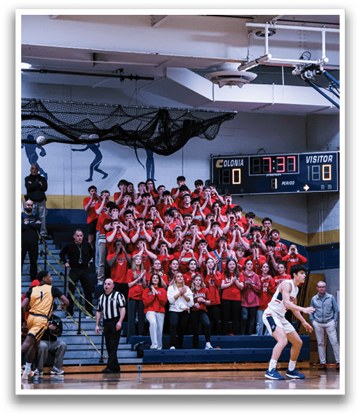 A basketball game is taking place with a crowd of people watching. The players are wearing red and white uniforms, and one player is holding a basketball. The spectators are seated on chairs and benches, and some are standing. The crowd is enthusiastic and engaged in the game. AI generated content