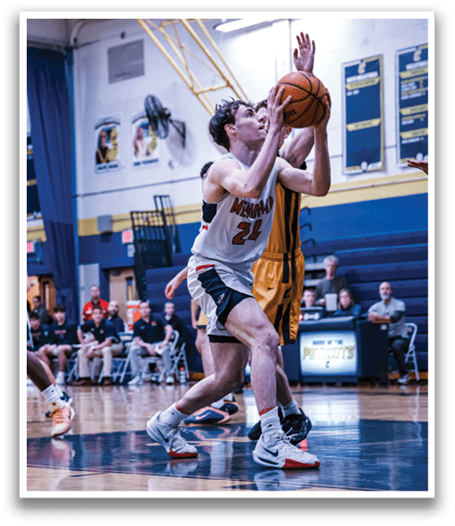A basketball game is in progress with players on the court. One player is attempting to block a shot, while another player is trying to grab the ball. There are several other players on the court, some of whom are sitting on chairs. A basketball is visible in the air, and a sports ball is also present on the court. AI generated content