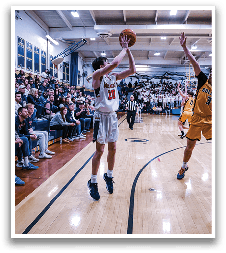 A basketball game is taking place with two teams playing. One player is attempting to shoot the ball while the other team's player tries to block the shot. The crowd is watching the game intently. AI generated content