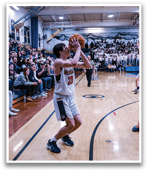 A basketball game is taking place with a crowd of people watching. Two men are playing, one holding a basketball and the other trying to block him. The players are wearing uniforms and the basketball is in motion. AI generated content