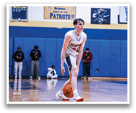 A basketball game is taking place with two teams playing. One player is holding the ball and another player is trying to block him. The players are wearing uniforms and are actively engaged in the game. AI generated content