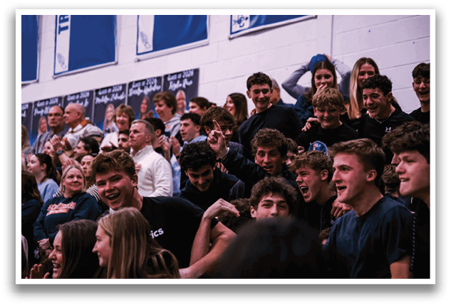 A group of people are sitting in a stadium, watching a game. They are all wearing black shirts and are engaged in the event. AI generated content