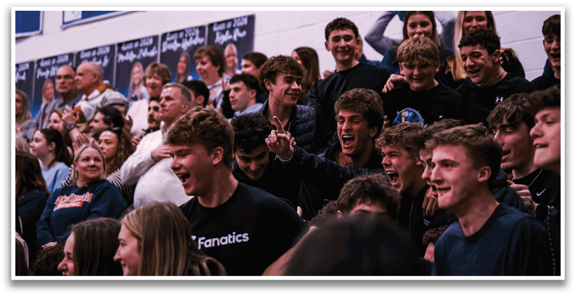 A group of people are sitting in a stadium, watching a game. They are wearing black shirts and are excited about the event. AI generated content