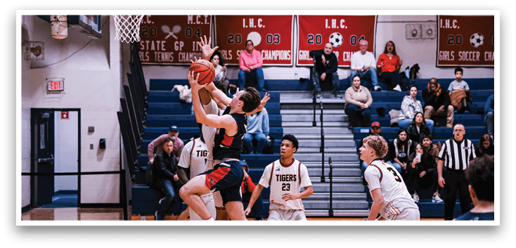 A basketball game is taking place with players on the court. A man is jumping in the air to shoot a basketball while others look on. The game is being played in a gym with a crowd of people watching. AI generated content