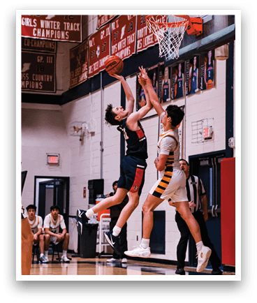 Two basketball players are fighting for a rebound, with one player jumping in the air to grab the ball. AI generated content