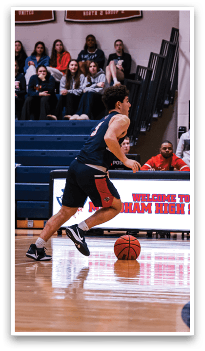 A basketball game is taking place with two teams playing. One player is running with the ball while others are watching. The crowd is watching the game intently. AI generated content