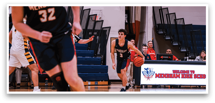 A basketball game is taking place with players on the court. A man is holding a basketball and is about to shoot it. There are other players on the court, some of them wearing shorts. A bench is visible in the background. AI generated content