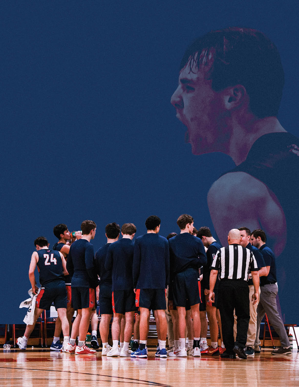 A group of men are standing on a basketball court, wearing blue uniforms. They are gathered around each other, engaged in conversation. The men are wearing shorts and some are wearing ties. The scene appears to be a casual gathering of friends or teammates. AI generated content