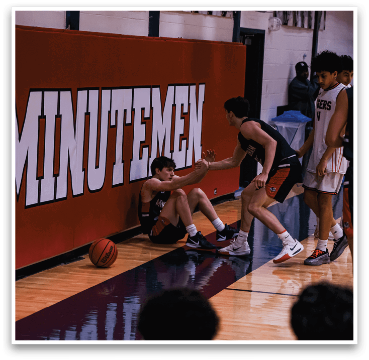 A group of men playing basketball, one of them is sitting on the ground. AI generated content