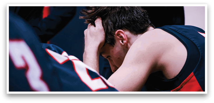 A man with a blue shirt and a number 23 on it is sitting down with his head in his hands. AI generated content