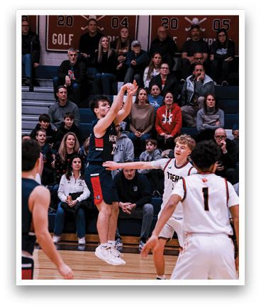 A basketball game is taking place with a player in the air attempting to shoot the ball. The crowd is watching intently as the player jumps up to make the shot. AI generated content