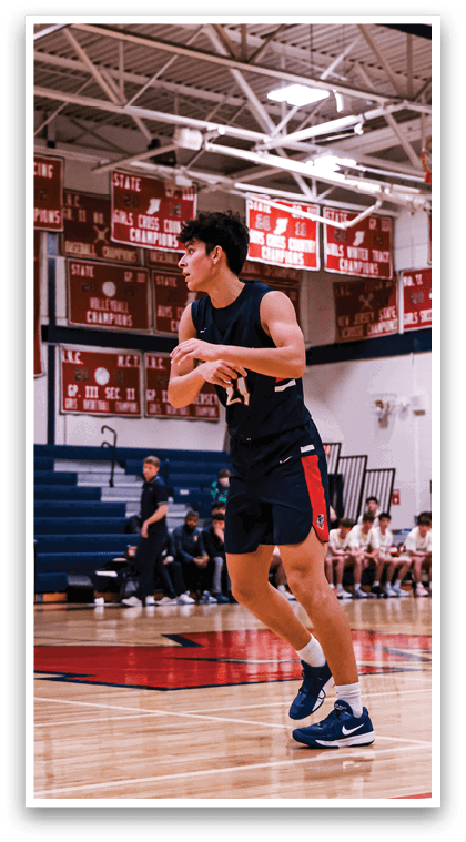 A man wearing a black shirt and shorts is holding a basketball in a gym. AI generated content