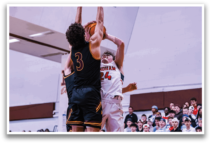 Two basketball players are leaping for the ball, one wearing a red jersey and the other wearing a white jersey. The players are in the air, with the red jersey player reaching for the ball. The game is being watched by a crowd of people who are seated on chairs. AI generated content