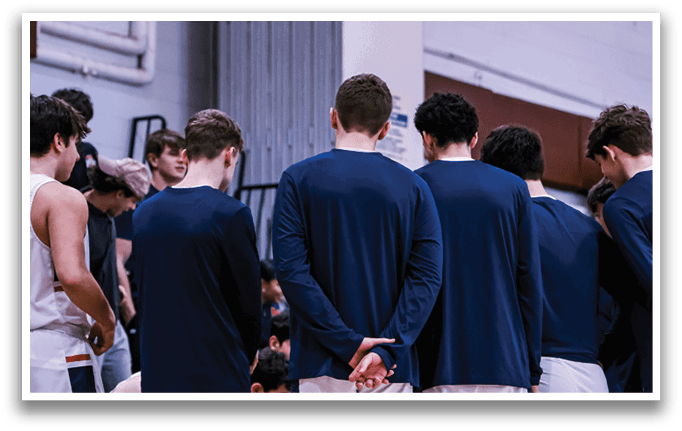 A group of men wearing blue shirts and white shorts are standing in a circle on a basketball court. AI generated content
