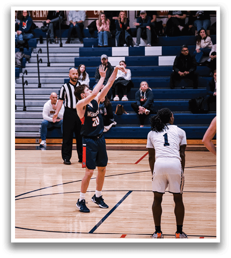 A basketball game is taking place with a player in the air, attempting to shoot the ball. The crowd is watching the game intently. AI generated content