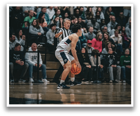 A basketball player is sitting on the floor with his legs crossed while another player stands nearby. AI generated content