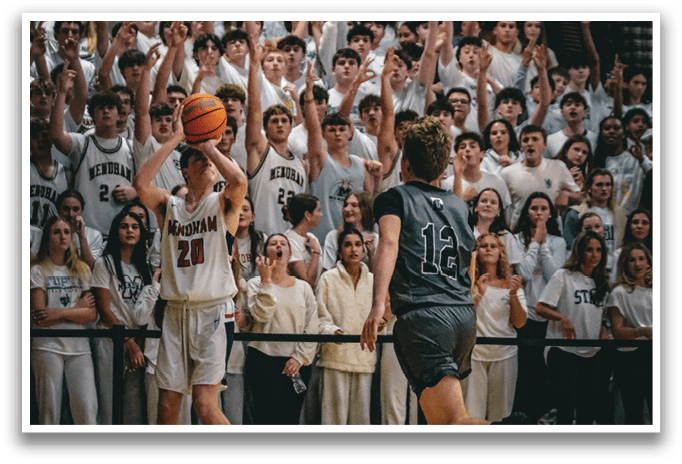 A basketball game is taking place with a crowd of people watching. A man is holding a basketball and is about to throw it. A woman is running towards him, trying to block the shot. AI generated content