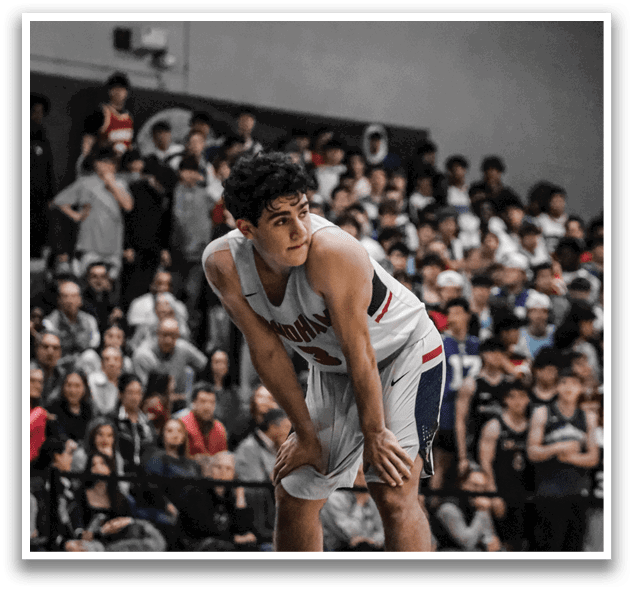 A basketball player is crouched down on the court, holding his knee in pain. AI generated content