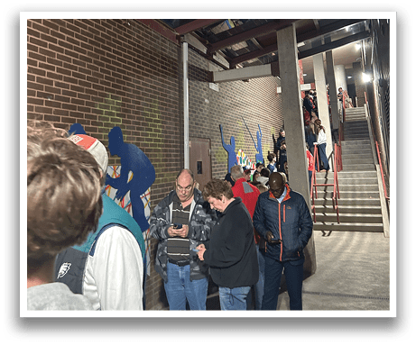 A group of people are standing outside a building, looking at their cell phones. AI generated content