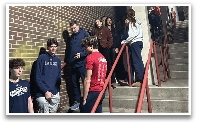 A group of people are standing on a staircase, some of them wearing blue shirts. AI generated content