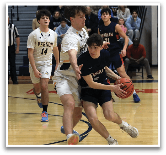 A basketball game is taking place with players from different teams. One player is trying to block the shot of another player who is holding the ball. The players are wearing uniforms and are actively engaged in the game. AI generated content