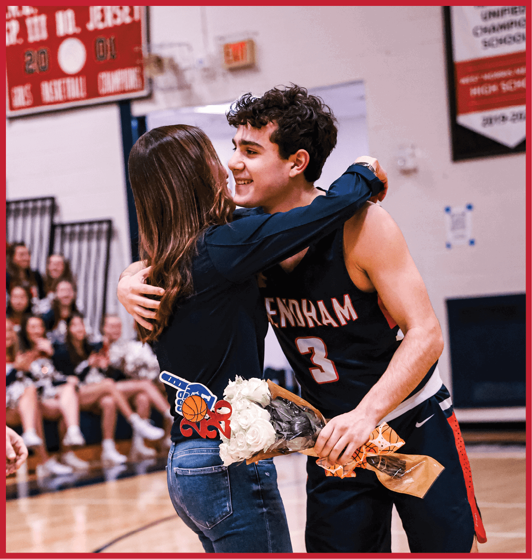 A man and a woman are hugging on a basketball court. The woman is holding a bouquet of flowers. AI generated content