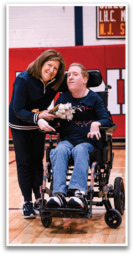 A man in a wheelchair is holding a bouquet of flowers while a woman stands beside him. AI generated content