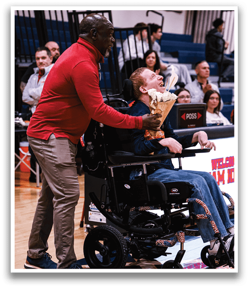 A man in a wheelchair is being fed a rose by another man. AI generated content