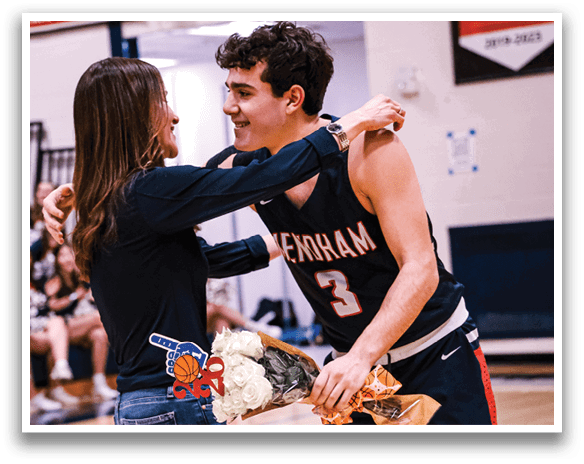A man and a woman are hugging each other on a basketball court. The woman is holding a bouquet of flowers. AI generated content